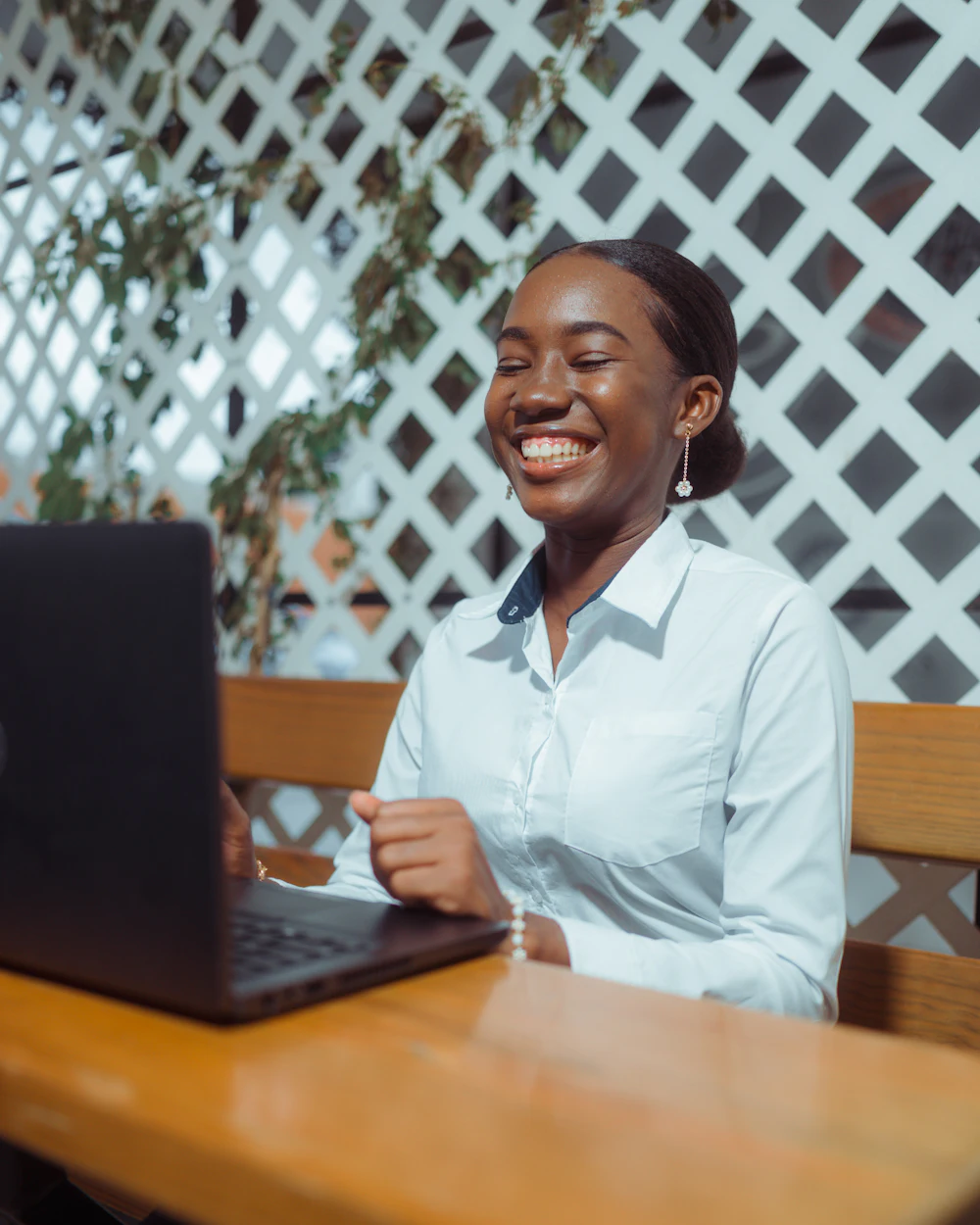 Entrepreneure souriante qui soumet un projet sur son ordinateur